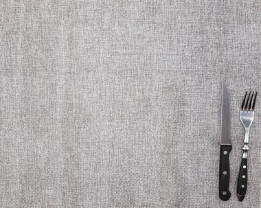Bir çatal ve bıçak ile kaba keten kumaştan masa örtüsü. Başlık sayfası veya menü kafe ya da Restoran için yaratıcı arka plan.