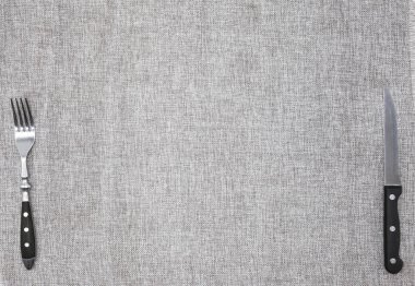 Bir çatal ve bıçak ile kaba keten kumaştan masa örtüsü. Başlık sayfası veya menü kafe ya da Restoran için yaratıcı arka plan.