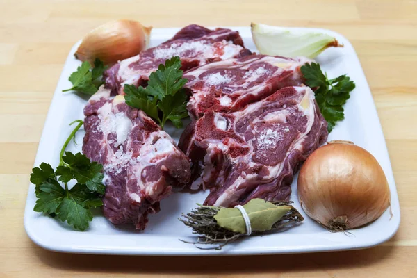 Pedaços de cordeiro fresco no prato. Delicioso cordeiro de cauda gorda com cebola no prato. Carne a grelhar . — Fotografia de Stock