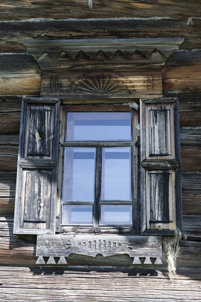 Stare okna ze szkła, na tle błękitnego nieba, drewniane ściany domu dziennika wsi — Zdjęcie stockowe