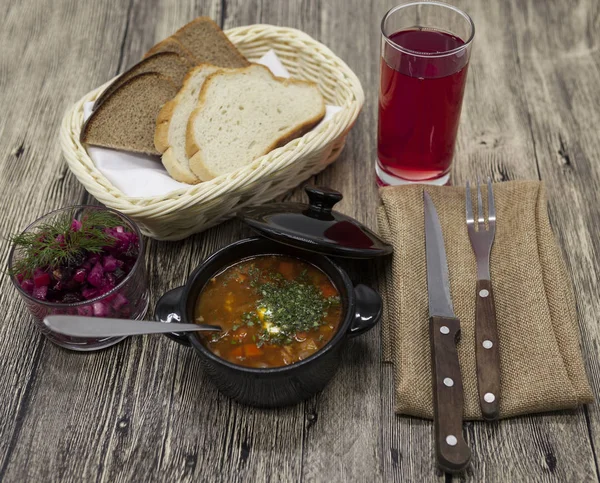 Rustik yemek sığır eti ile domates çorbası, masada pancar salatası.