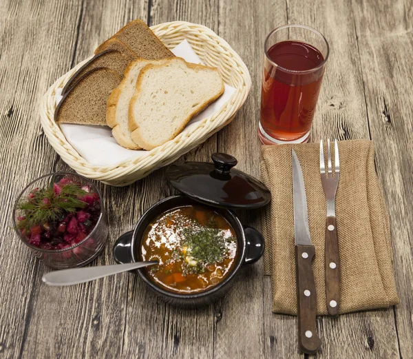 Сельский обед из томатного супа с говядиной, свекольный салат на столе . — стоковое фото
