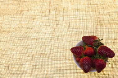 Olgun çilek yakın çekim bir tuval zemin üzerine vazo.