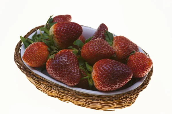 Saftige Beeren von reifen Erdbeeren in einem Weidenkorb auf weißem Hintergrund. — Stockfoto