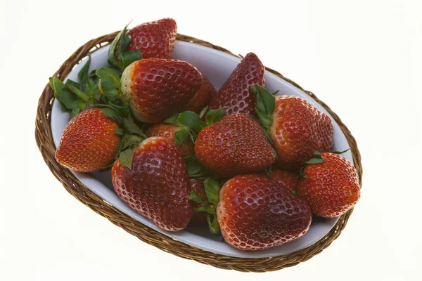 Juicy berries of ripe strawberries in a wicker basket on a white background. — Stock Photo, Image