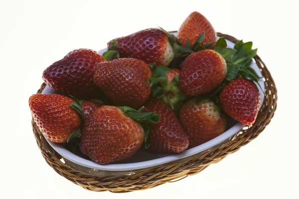 Juicy berries of ripe strawberries in a wicker basket on a white background. — Stock Photo, Image