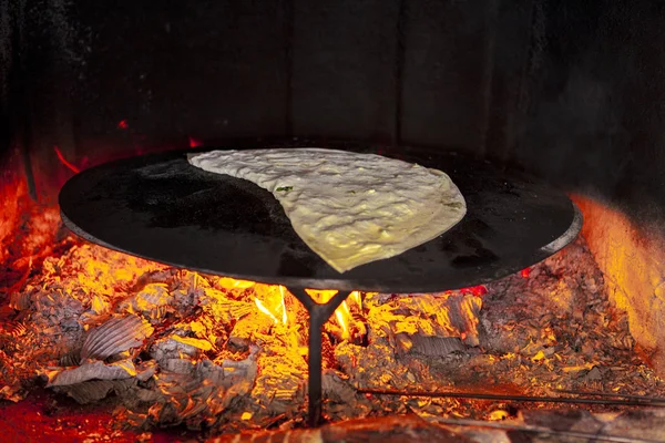 Home closed pizza with cheese and parsley fried in a home oven on fire.