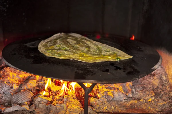 Home closed pizza with cheese and parsley fried in a home oven on fire.