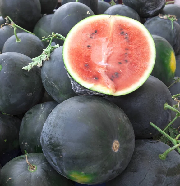 Melancias suculentas. Melancias no mercado de fazendeiros da Tunísia Uma grande fatia de melancia suculenta madura no mercado da aldeia . — Fotografia de Stock