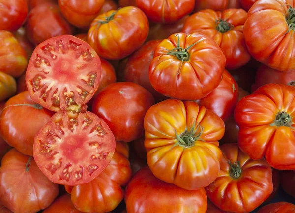 Zwei Hälften saftige reife Tomaten in der Sektion. frische Tomaten. Rote Tomaten. Dorfmarkt Bio-Tomaten. qualitativer Hintergrund von Tomaten. — Stockfoto