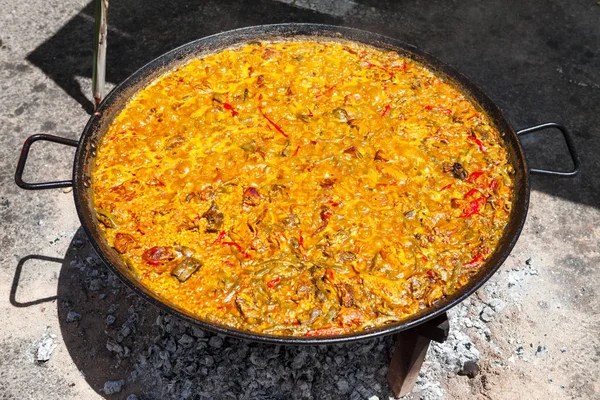 Paella ai frutti di mare. Il piatto nazionale spagnolo di paella in una padella grande è cucinato su un fuoco aperto, sul rogo . — Foto Stock