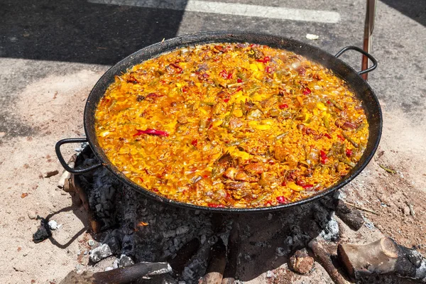 Paella ai frutti di mare. Il piatto nazionale spagnolo di paella in una padella grande è cucinato su un fuoco aperto, sul rogo . — Foto Stock