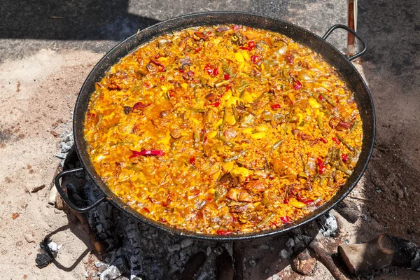 Paella ai frutti di mare. Il piatto nazionale spagnolo di paella in una padella grande è cucinato su un fuoco aperto, sul rogo . — Foto Stock