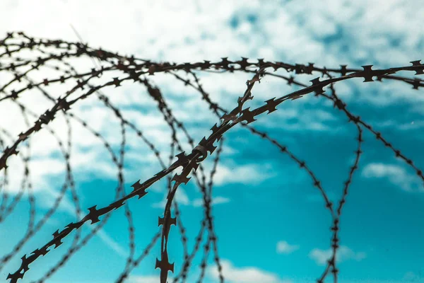 Barbed wire. Barbed wire on blue sky background with white clouds. Wire boom. Military conflict . Syria.