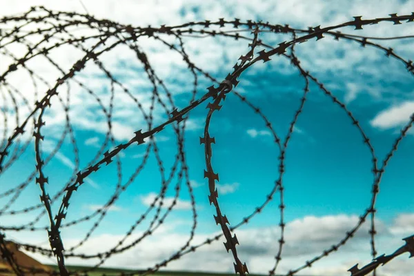 Barbed wire. Barbed wire on blue sky background with white clouds. Wire boom. Military conflict . Syria.