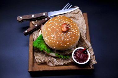 Sulu hamburger. Burger mermer sığır eti, çatal bıçak ve chili sos ile
