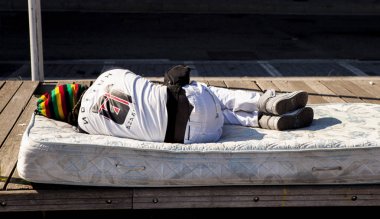 Evsiz bir insan sokakta yatıyor. Cenova, İtalya sokaklarında Afrika'dan mülteciler.