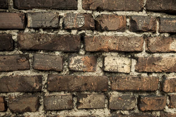 Muro de ladrillo, viejo ladrillo oscuro. El patrón de la estructura de una pared de ladrillo con mampostería. Viejo muro hogar europeo — Foto de Stock