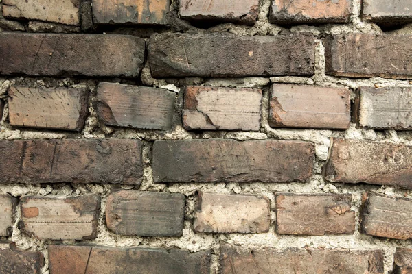 Muro de ladrillo, viejo ladrillo oscuro. El patrón de la estructura de una pared de ladrillo con mampostería. Viejo muro hogar europeo — Foto de Stock