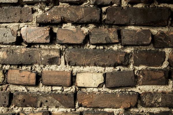 Muro de ladrillo, viejo ladrillo oscuro. El patrón de la estructura de una pared de ladrillo con mampostería. Viejo muro hogar europeo — Foto de Stock