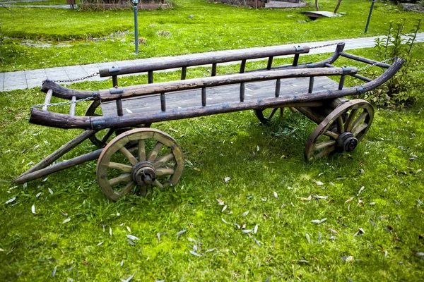 Carrinho cigano. Carrinho velho na grama verde na parte de trás da casa no dia de verão . — Fotografia de Stock