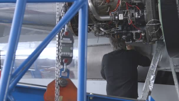 Instalação de Reparação de Aeronaves. Homem a reparar aviões. 2 tiros — Vídeo de Stock