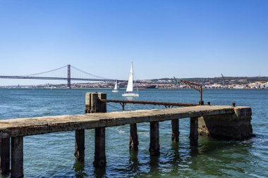 Lizbon 'un panoramik manzarası ve Portekiz' in Cacilhas kentindeki Tagus Nehri 'nin güney kıyısından 25 Nisan Köprüsü.