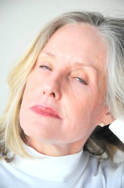 Mature female blond beauty expressions alone outside.