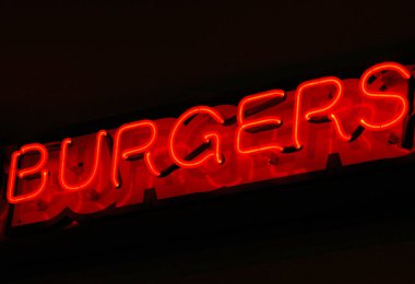 Burger neon levhası açık havada duvarda asılı..