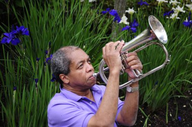 Afrikalı Amerikalı caz trompetçisi dışarıda kornasını çalıyor..