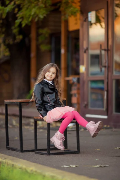 Длинноволосая девушка машет ногами на скамейке — стоковое фото