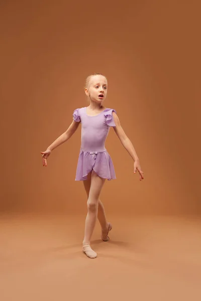 Nettes Mädchen im lila Kleid zeigt Elemente des Balletts — Stockfoto