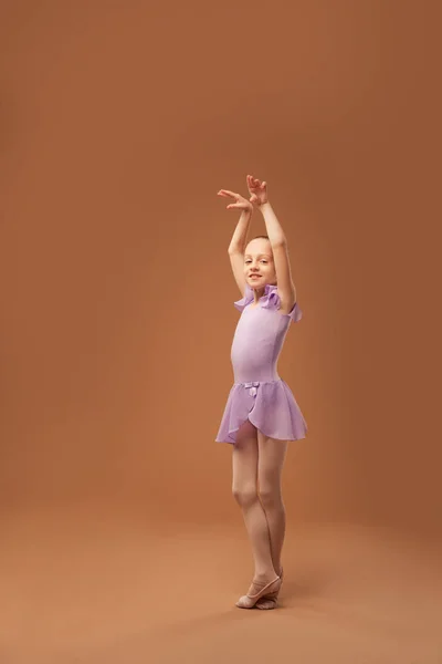 Menina em um vestido roxo mostra elementos de balé — Fotografia de Stock