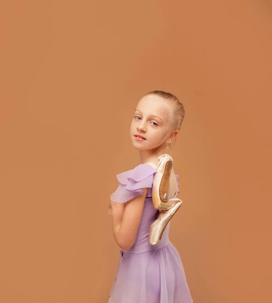 Mladá baletka školního věku drží dobře opotřebované špičaté boty — Stock fotografie