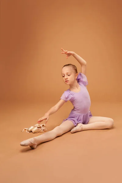 Nettes Mädchen im lila Kleid zeigt Elemente des Balletts — Stockfoto