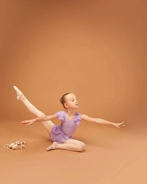 Cute girl in a purple dress shows elements of ballet — Stock Photo, Image