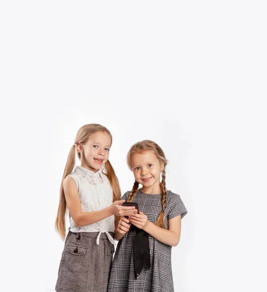 Dwie Dziewczyny Trzymają Telefon Komórkowy Rękach Uczą Się Nim Jest — Zdjęcie stockowe