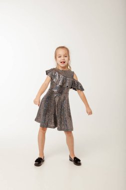 Payet elbiseli küçük kız dans ediyor.