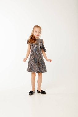 Payet elbiseli küçük kız dans ediyor.