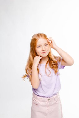 Kızıl saçlı, uzun saçlı, günlük kıyafetleri olan bir kız.)