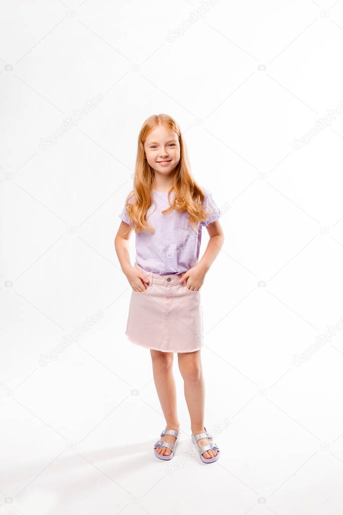 cute red-haired girl in ordinary clothes is standing and smiling