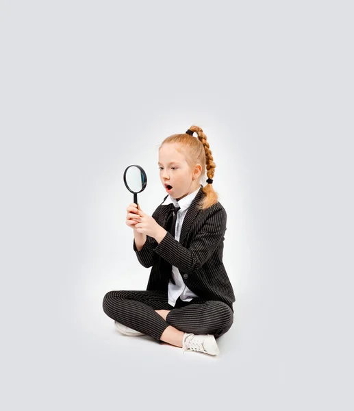 Girl Business Black Suit Sits Cross Legged Looks Surprise Magnifying — Stock Photo, Image