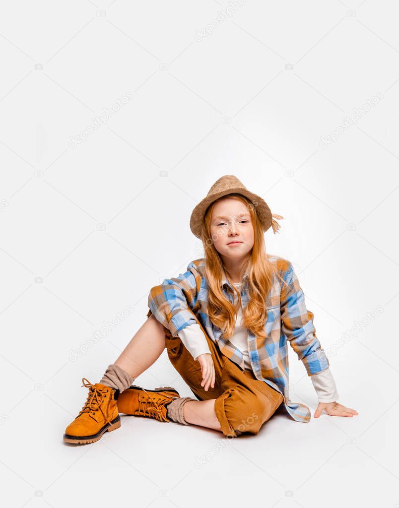 long-haired emotional girl in traveler clothes sits on the floor