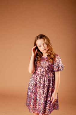 Payet elbiseli tatlı düşünceli kız saçlarına dokunuyor.