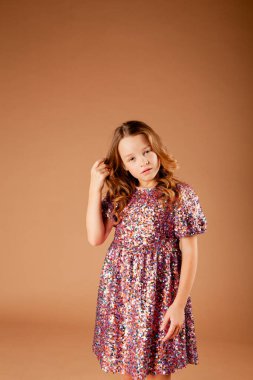 Payet elbiseli tatlı düşünceli kız saçlarına dokunuyor.