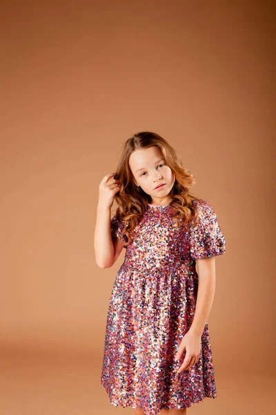 Payet elbiseli tatlı düşünceli kız saçlarına dokunuyor.