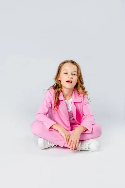 Nettes Mädchen Rosa Trainingsanzug Und Turnschuhen Sitzt Auf Hellgrauem Hintergrund — Stockfoto