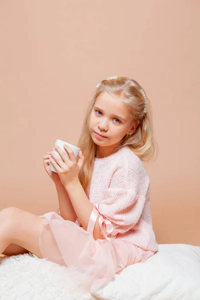 Ξανθιά Κοπέλα Κάθεται Ένα Φλιτζάνι Στα Χέρια Της Ένα Ροζ — Φωτογραφία Αρχείου