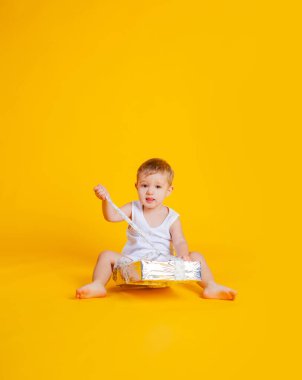 Çocuk büyük bir hediye kutusunun yanında tişört ve iç çamaşırıyla oturuyor..