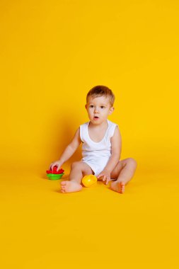 Çocuk oturur ve piramit gibi eğitici bir oyunun detaylarını birbirine bağlamaya çalışır.